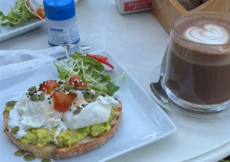 Poached eggs and avocado on sourdough with seeds and cherry tomatoes