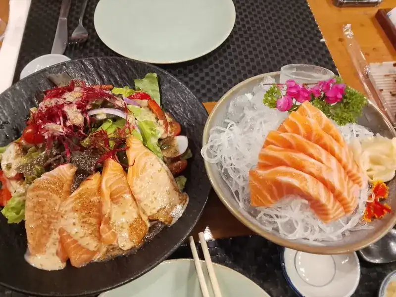 Salmon salad beside a plate of salmon sashimi on shredded radish / สลัดแซลมอนคู่กับซาชิมิแซลมอนบนหัวไชเท้าซอย