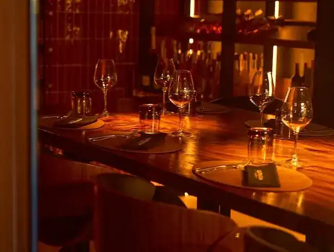 Candle-lit table set with glasses in the wine room
