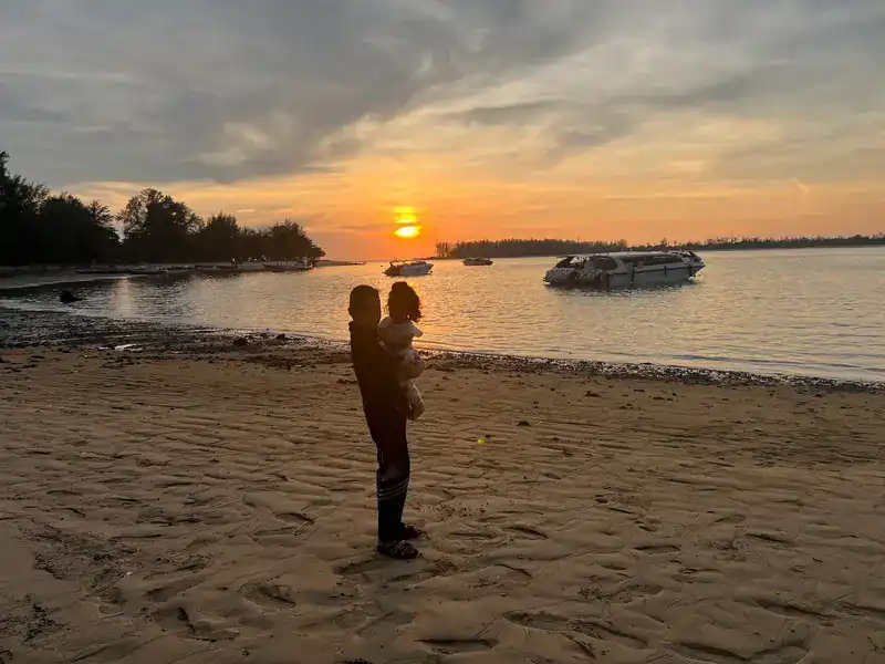 Sunset over the beach, with boats at anchor offshore