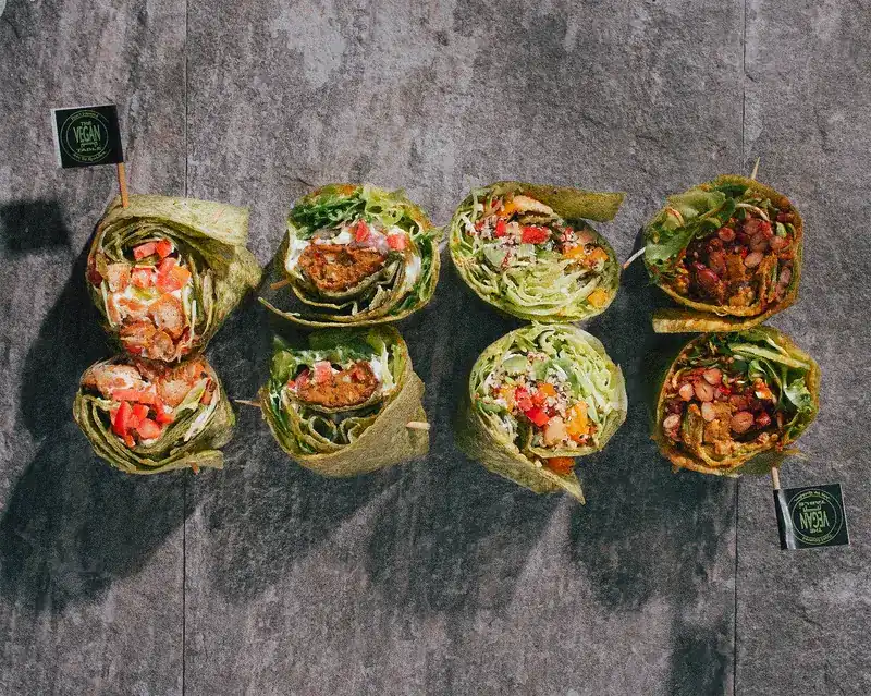 Eight halved wraps with different fillings laid out on the stone table