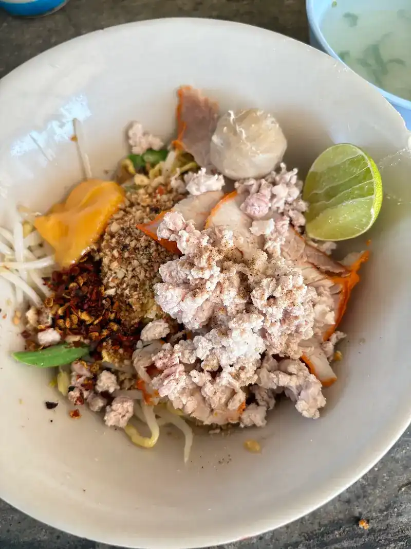 Dry noodles with minced pork, red pork, a pork ball, ground peanuts, chilli and lime / ก๋วยเตี๋ยวแห้ง ใส่หมูสับ หมูแดง ลูกชิ้น ถั่วลิสงป่น พริกป่น และมะนาว