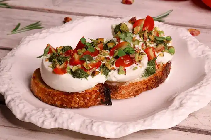 Burrata and tomato on sourdough with pistachio