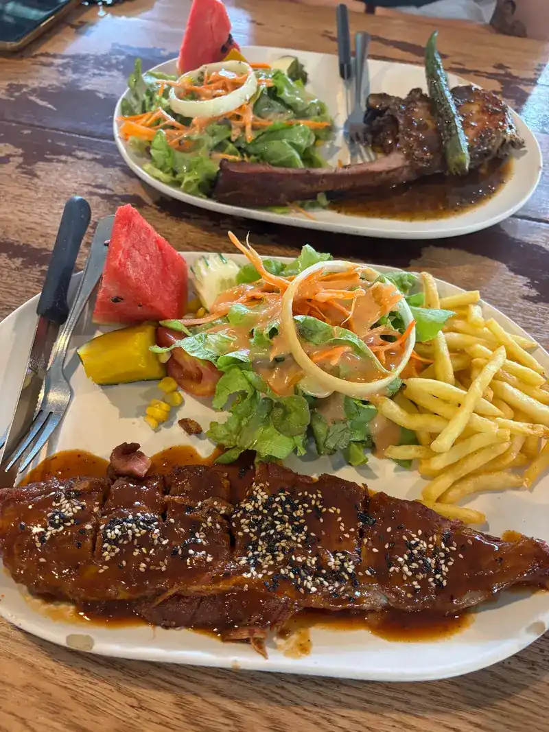 Ribs glazed with sauce and sesame, with fries and salad