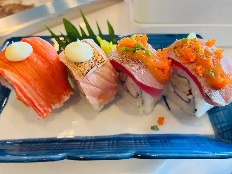 Four torched sushi rolls, two with mayonnaise and two with fish roe