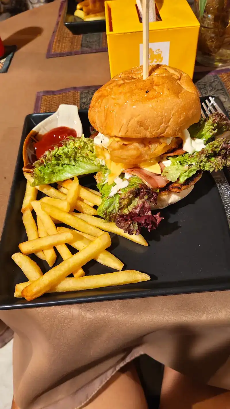 Burger with lettuce and a side of fries and ketchup on a black plate