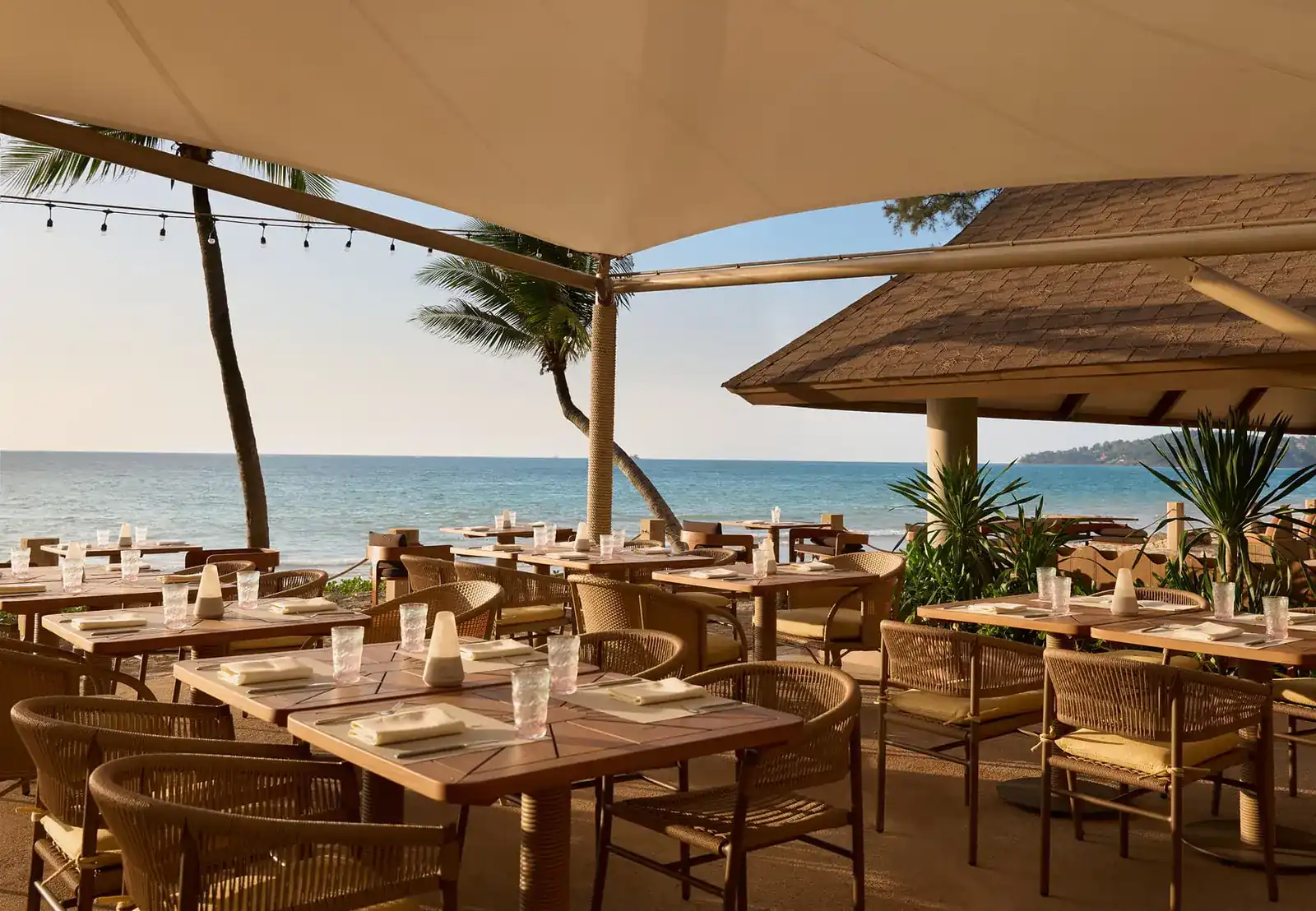 Dining terrace under white sails, facing the Andaman Sea on Bang Tao Beach