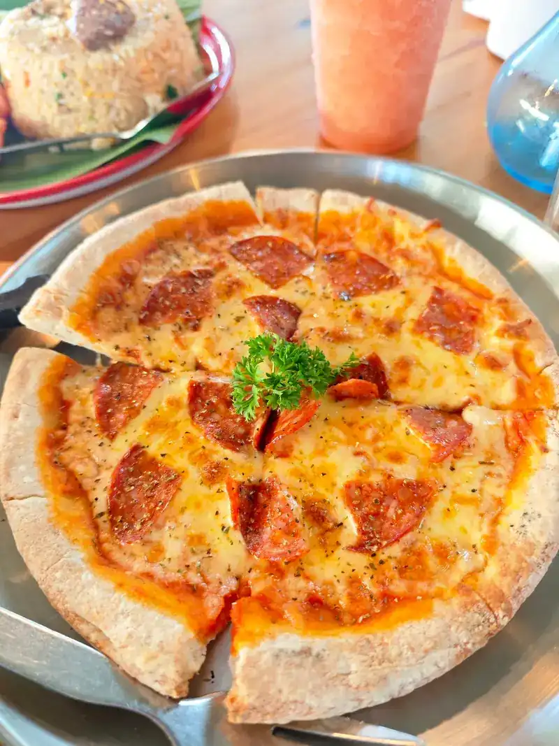 Pepperoni pizza on a metal tray, fried rice behind it