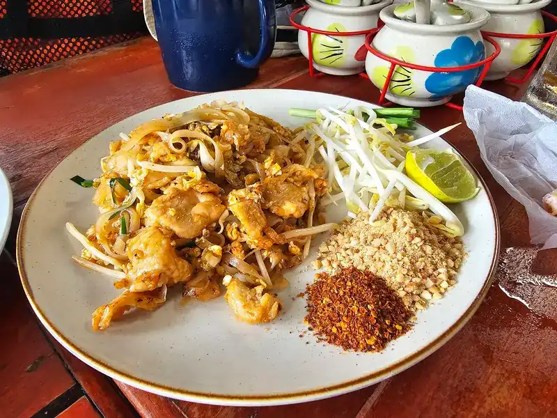 Pad thai with bean sprouts, lime, crushed peanuts and chilli flakes on the side