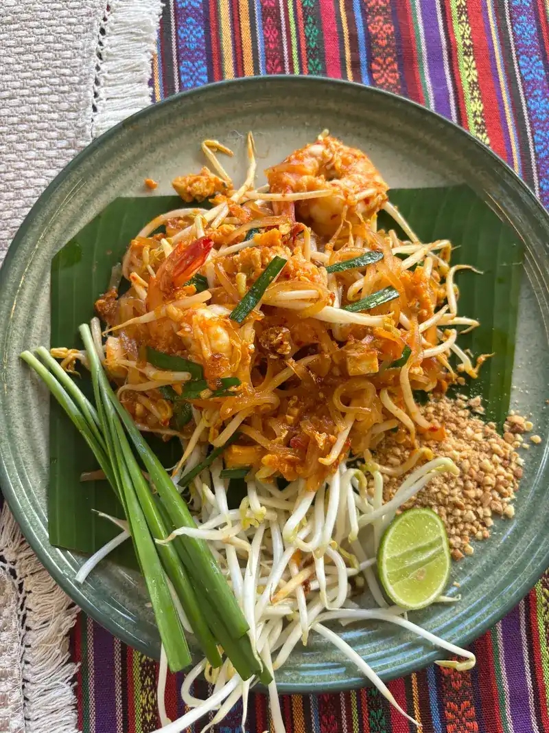 Pad thai with prawns, crushed peanuts, lime, bean sprouts and chives