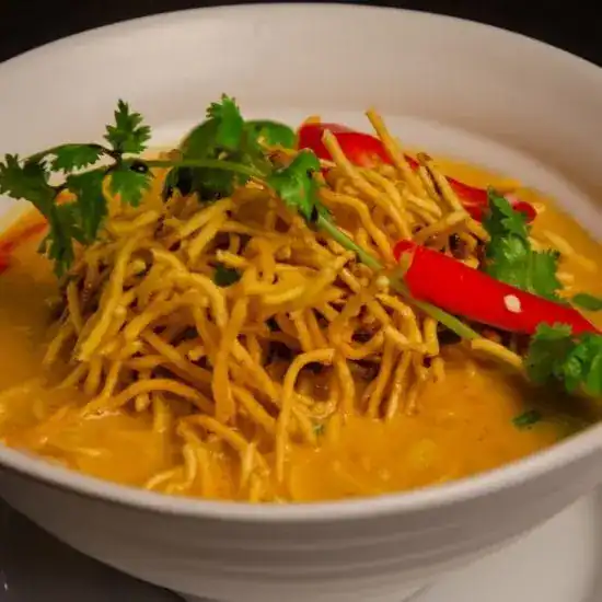 Khao Soy, curry noodle soup topped with crispy noodles, chili and coriander