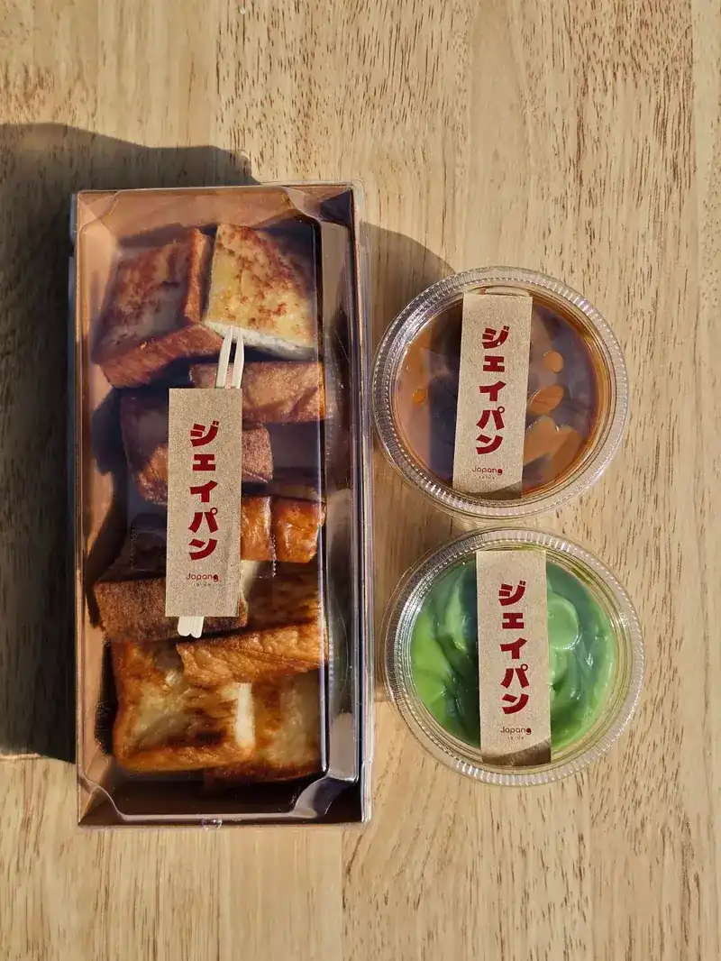 A box of grilled shokupan pieces with two cups of custard for dipping, each tagged ジェイパン