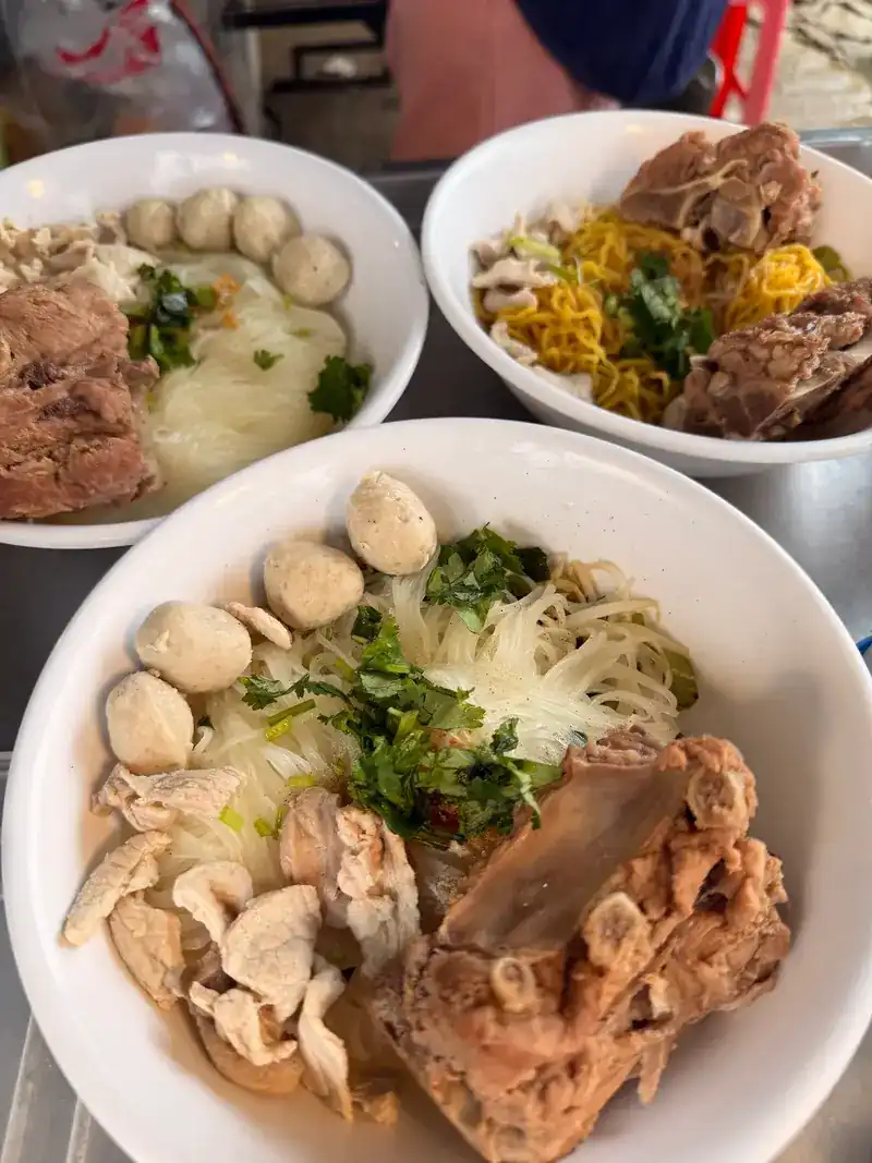 Three bowls with meatballs, rib and noodles