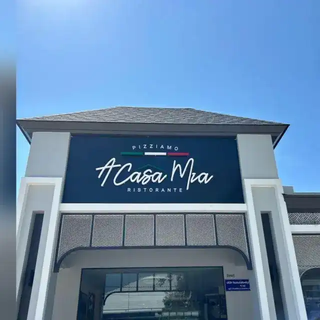 The white front of Pizziamo A Casa Mia with its navy Ristorante sign under a blue sky