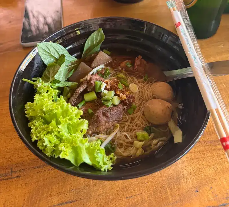 Braised noodle soup with rice vermicelli, meatballs, basil and lettuce