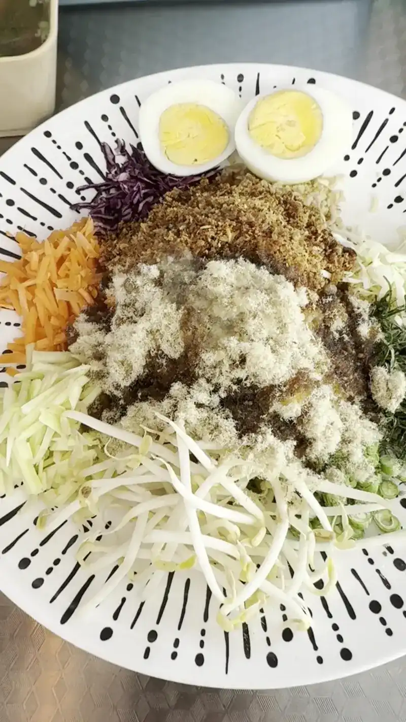 Khao yam, rice salad with bean sprouts, shredded vegetables and boiled egg