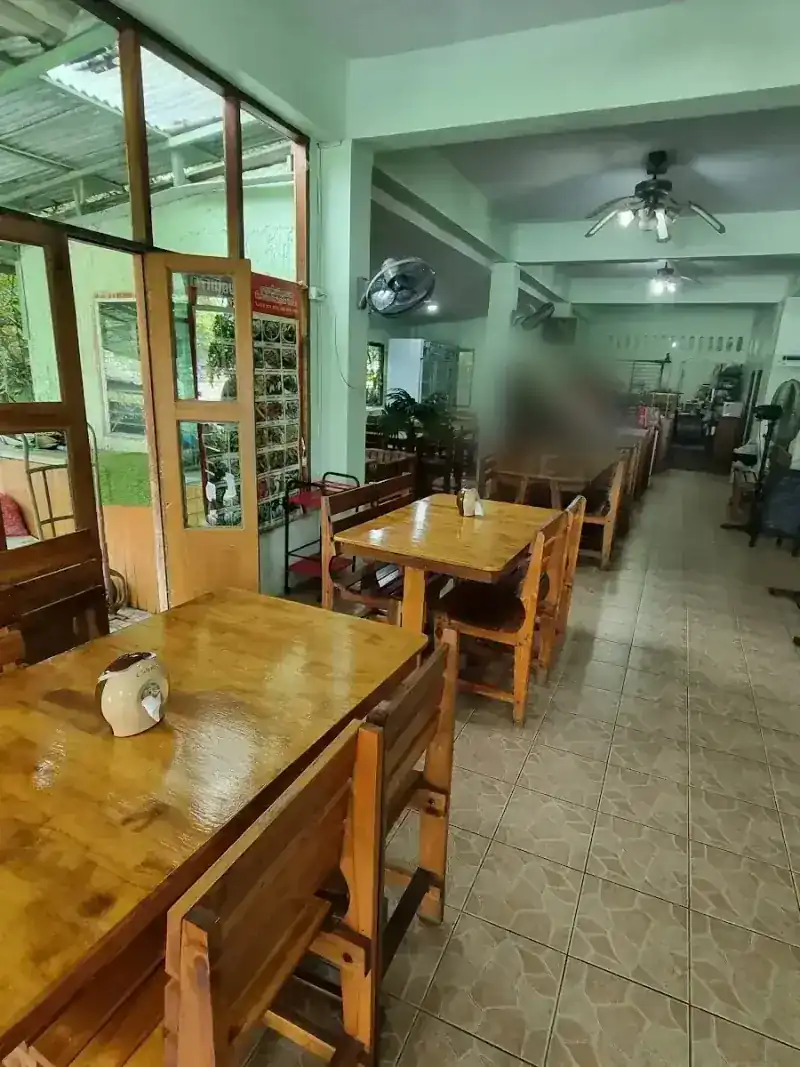 The dining room with wooden tables and chairs, ceiling fans, pale green walls and open doors