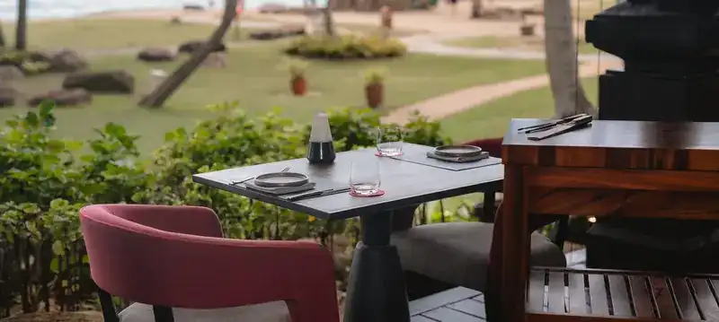 A table set on the terrace, looking over the garden towards the beach