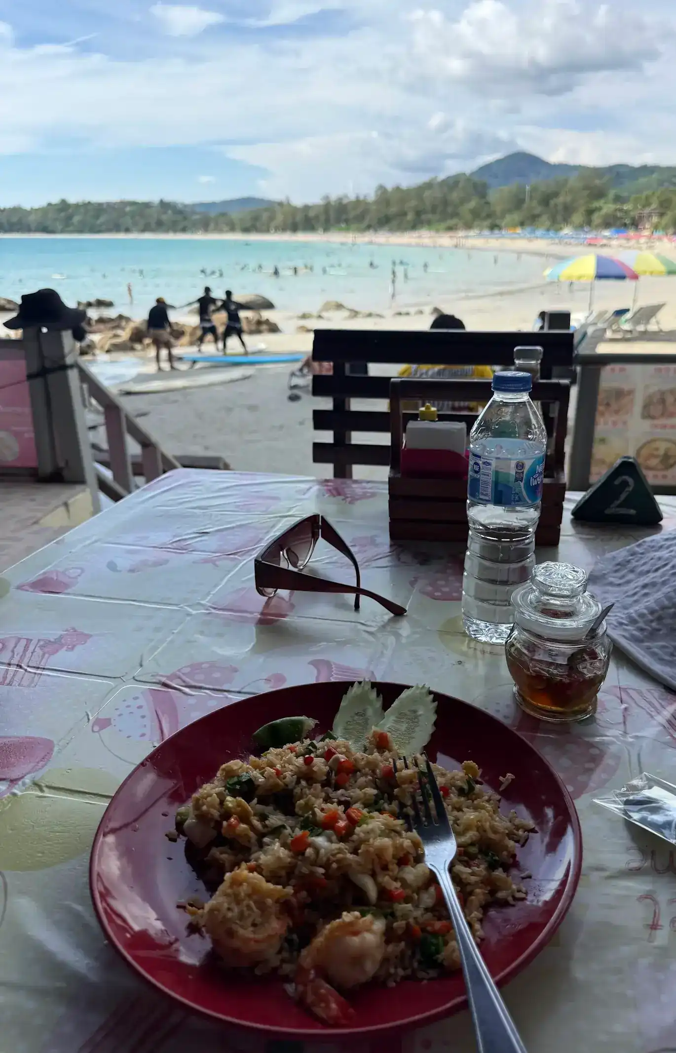 A plate of prawn fried rice on a table looking out over Kata Beach