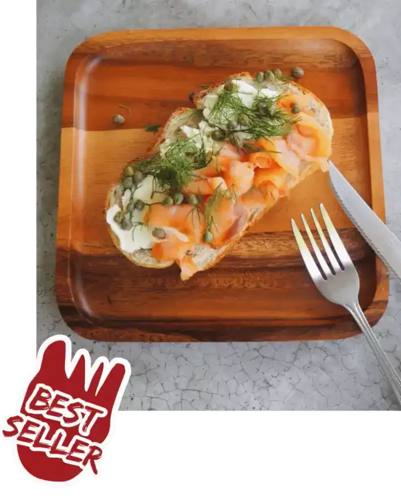 Smoked salmon, dill and capers on toast, served on a wooden tray