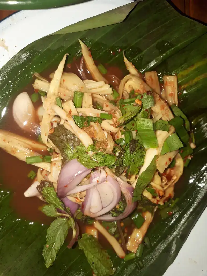 A spicy salad with shallots and mint on a banana leaf