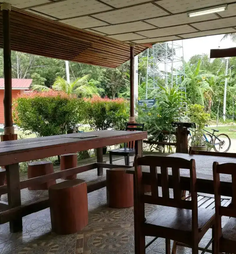 Wooden tables and log stools on the terrace, facing the garden / โต๊ะไม้และเก้าอี้ตอไม้ที่ระเบียง หันออกสู่สวน