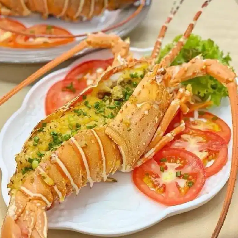 Grilled lobster with herbs on sliced tomato