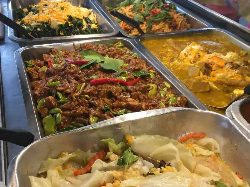 Steel trays of curries and stir-fries on the counter