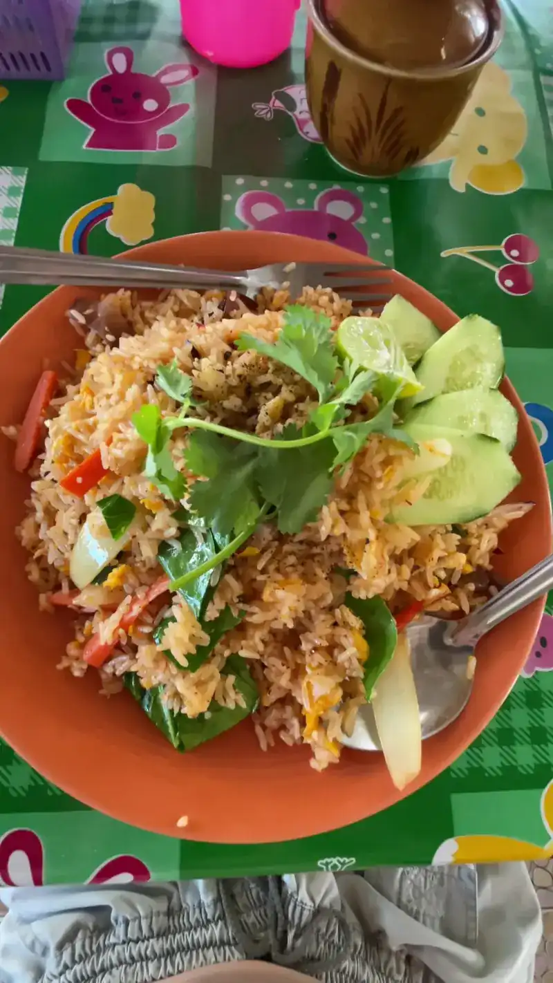 Fried rice with tomato, cucumber and coriander on an orange plate