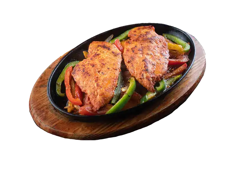 Sizzling chicken with peppers on a cast-iron plate