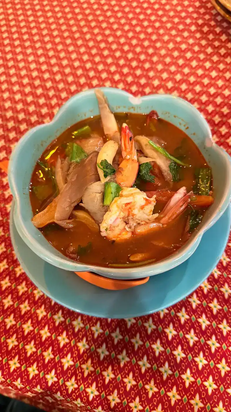 Tom yum with prawns in a blue bowl