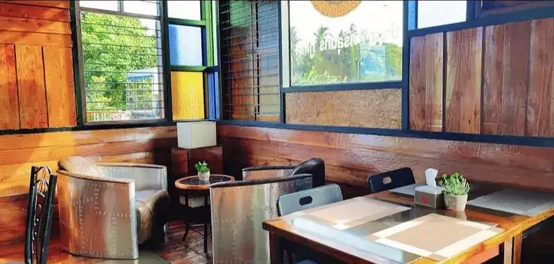 A corner with riveted metal armchairs and wood-panelled walls