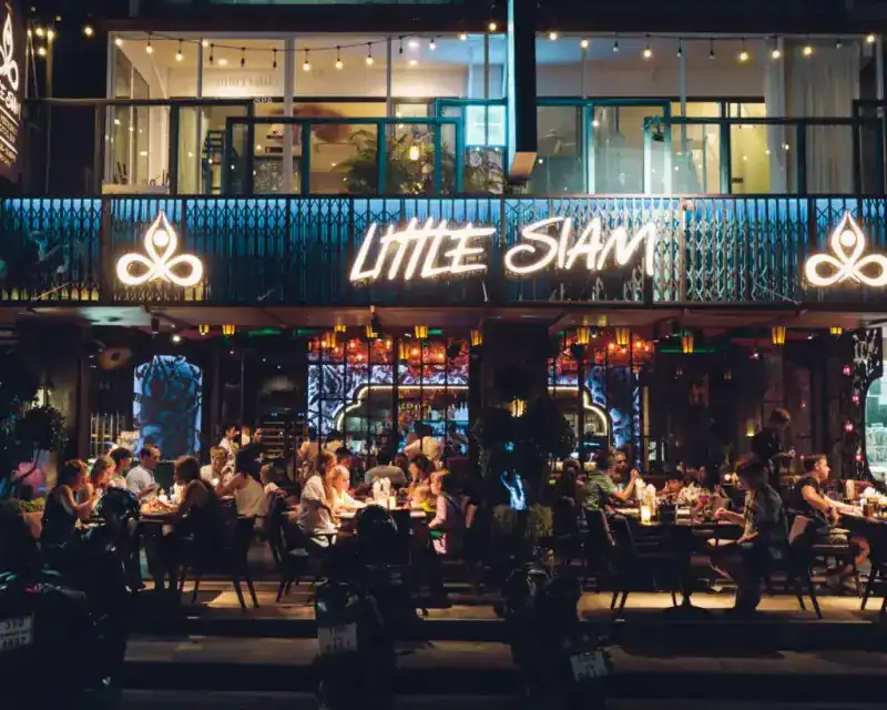 The Little Siam sign lit up above the terrace on Boat Avenue at night