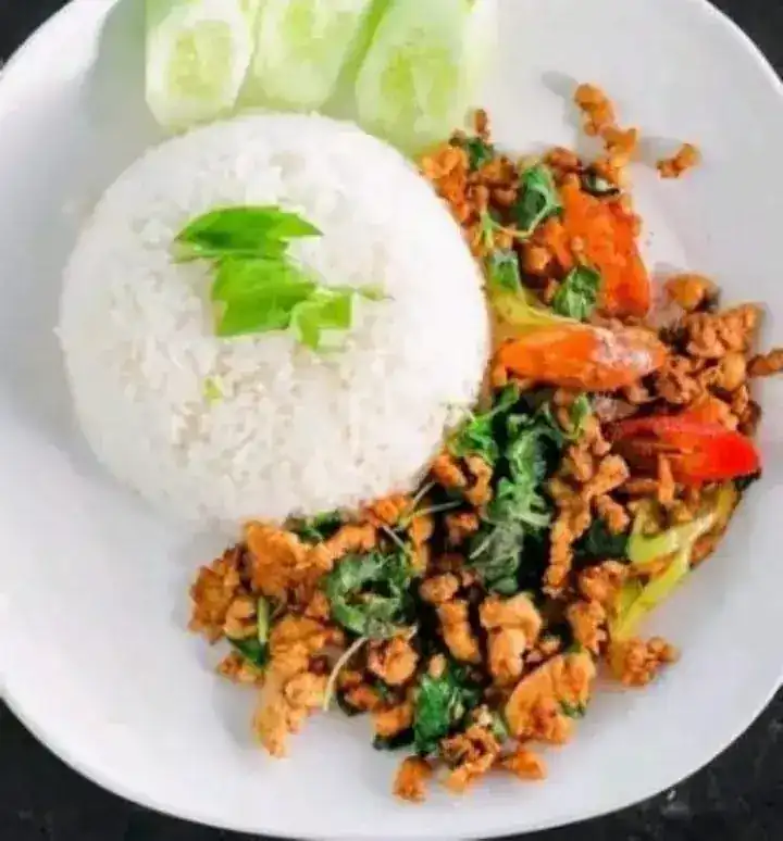 Minced meat stir-fried with holy basil and chilli, beside a dome of rice and sliced cucumber