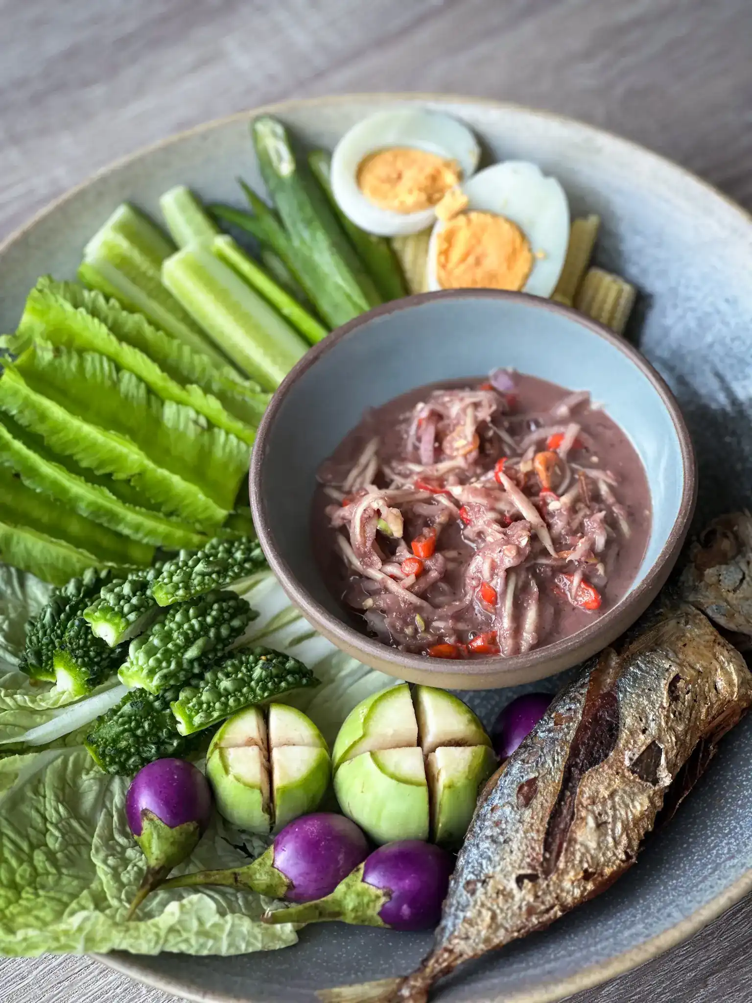 The nam chup set: a bowl of shrimp-paste chilli dip with fresh vegetables, a boiled egg and a fried fish