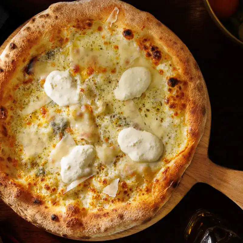 A white pizza on a wooden board / พิซซ่าซอสขาวบนเขียงไม้