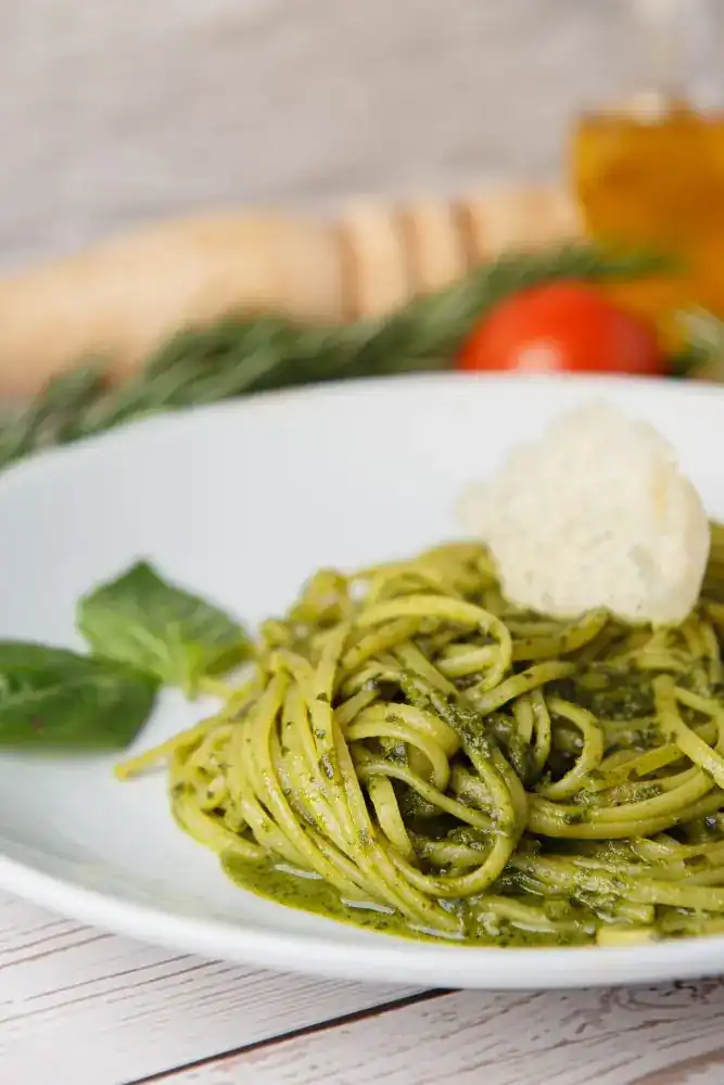 Linguine in green pesto with basil leaves