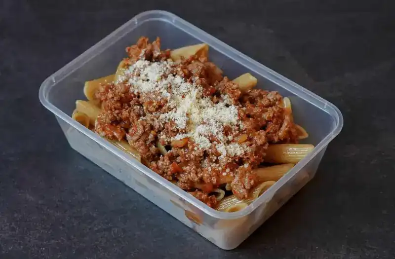 Wholegrain penne with beef bolognese and grated cheese in a meal-prep box