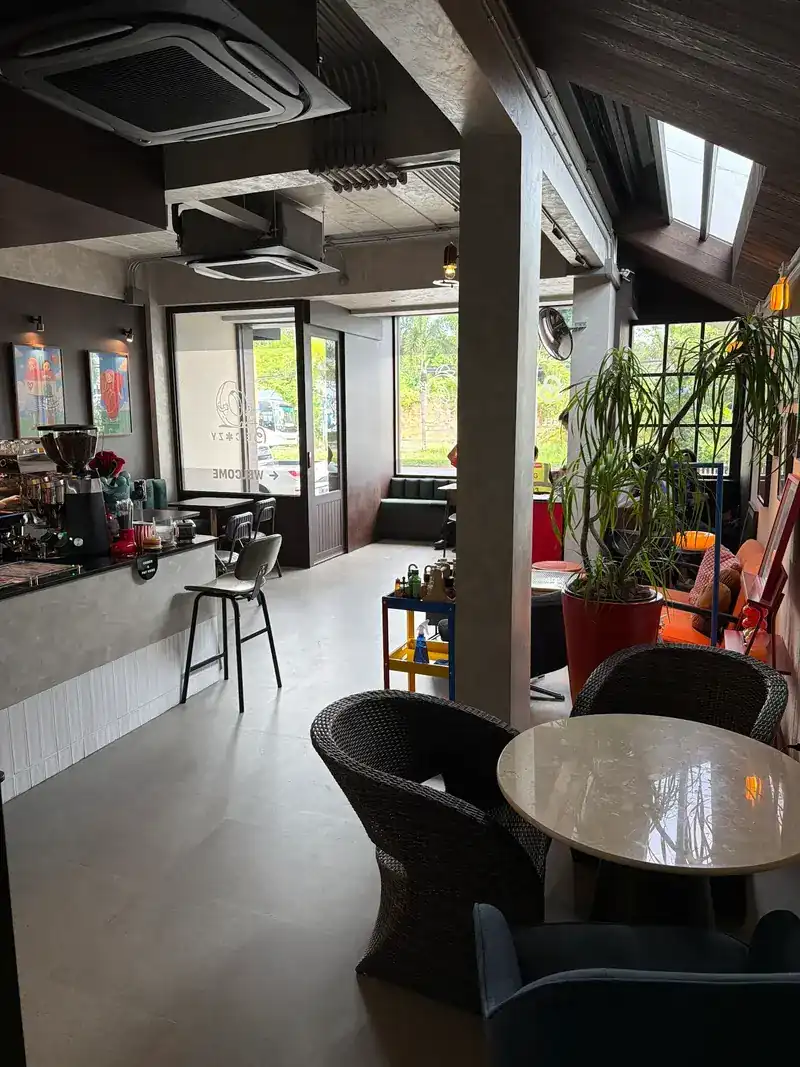 The room: the counter on the left, a round marble table and plants by the windows