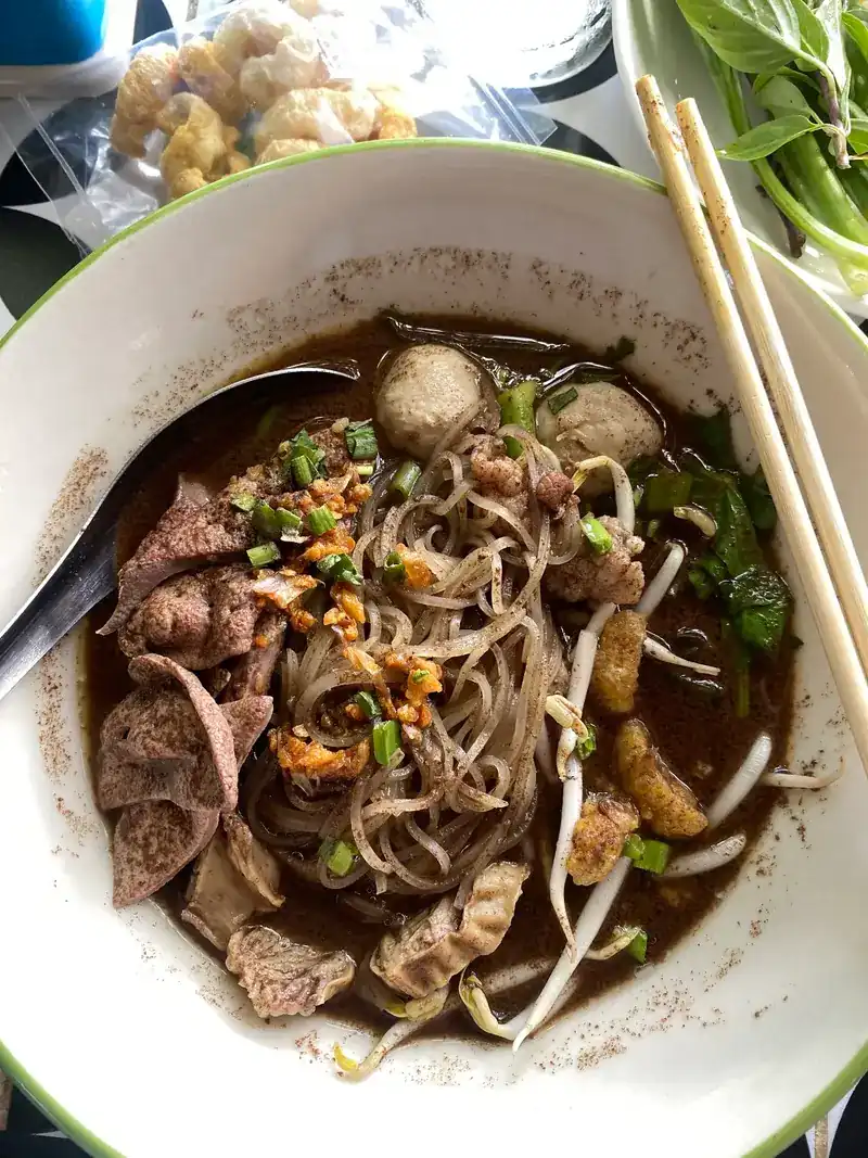 Boat noodles with sliced meat, meatballs, fried garlic and bean sprouts