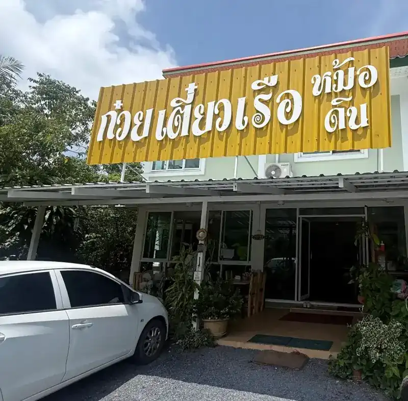 The shop front, with a yellow sign that reads boat noodles, clay pot