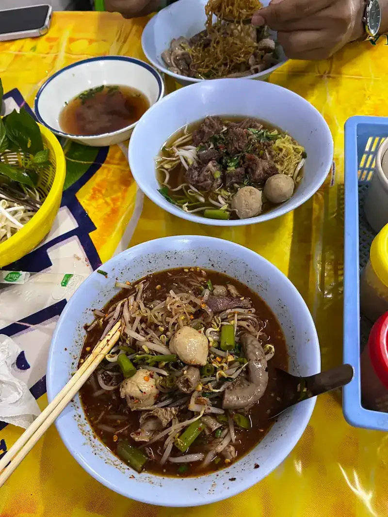 Egg noodles with meatballs and a bowl of noodle soup in dark broth / บะหมี่ใส่ลูกชิ้น และก๋วยเตี๋ยวน้ำซุปสีเข้ม