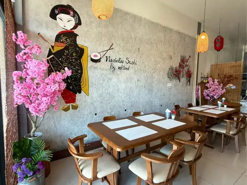 The dining room: wooden tables, pink blossom and a painted geisha on the wall