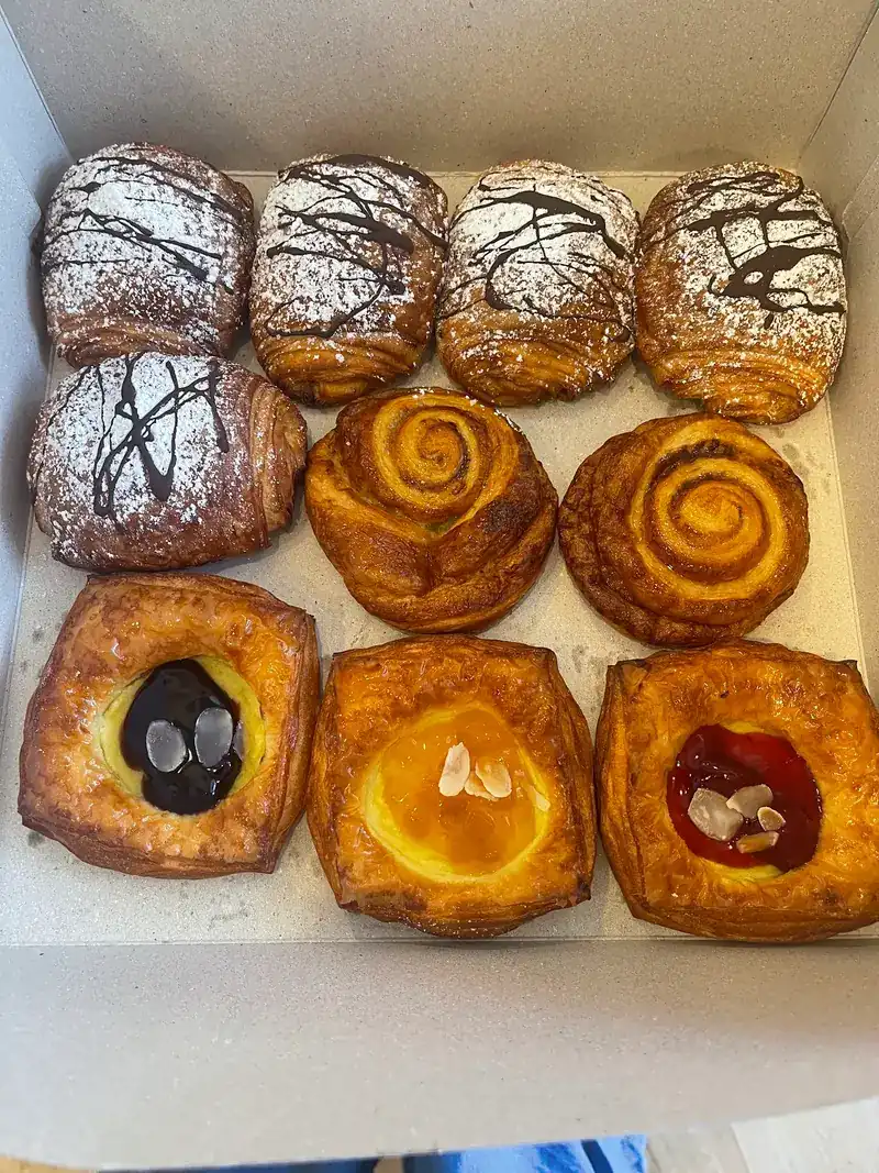 A box of pastries: chocolate croissants, swirl rolls and fruit danishes