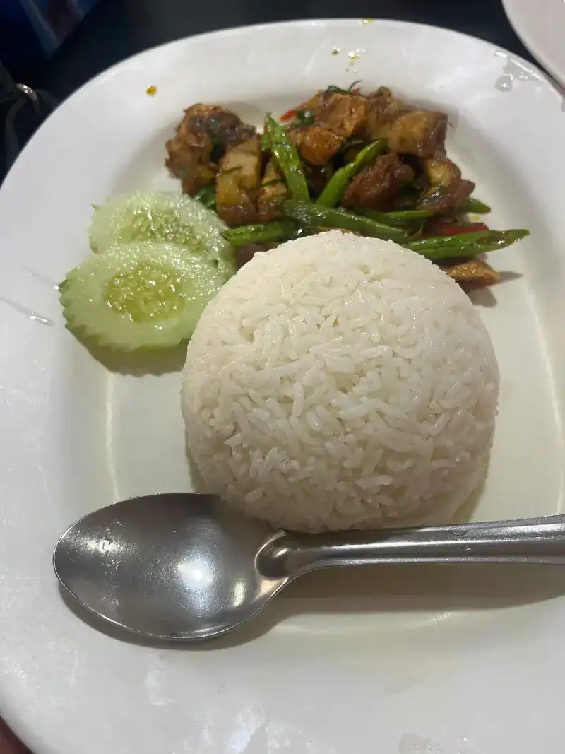 A stir-fry with long beans beside rice and sliced cucumber