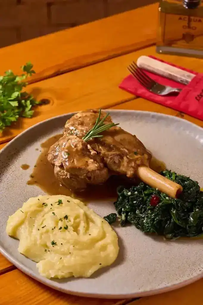 Braised shank in gravy with mashed potato and greens