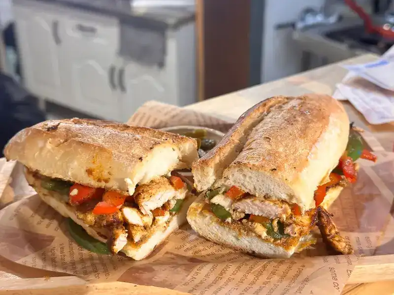 A toasted baguette filled with chicken and peppers