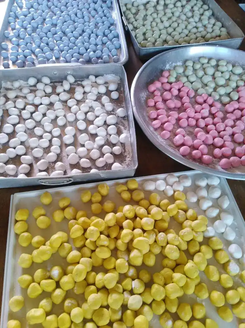 Trays of small dough balls in blue, green, pink, white and yellow