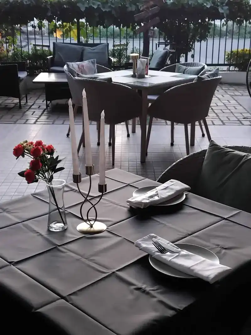 A terrace table set with candles and red roses