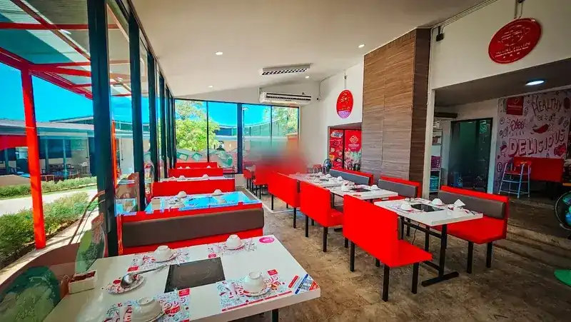 Inside: red booths and white tables along a wall of glass